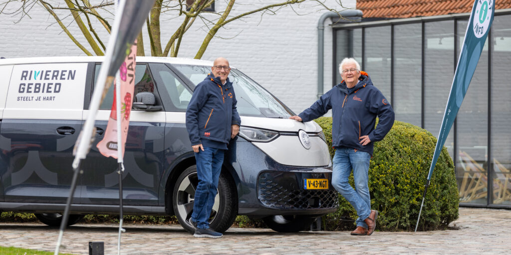 Vrijwilligers Tom en Frans bij de bus van Bureau Toerisme