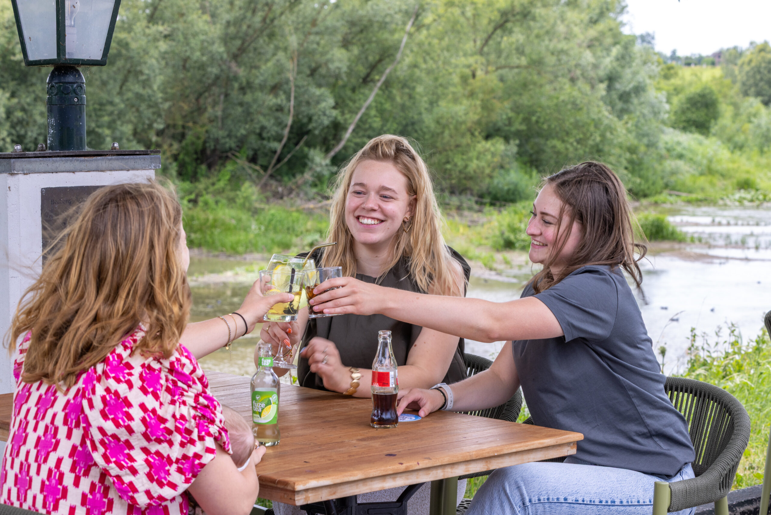 Gasten genieten samen op het terras van Bij de Engel aan het water