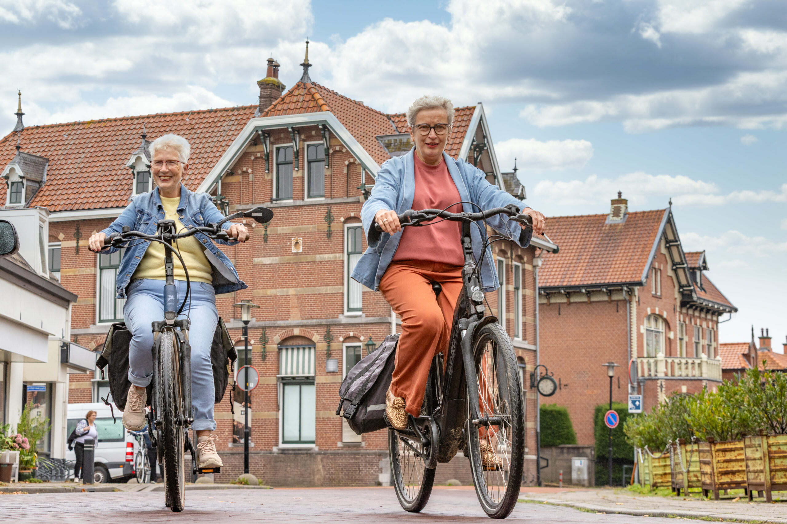 Twee fietsers op de Markt in het centrum van Druten, voor een historisch pand